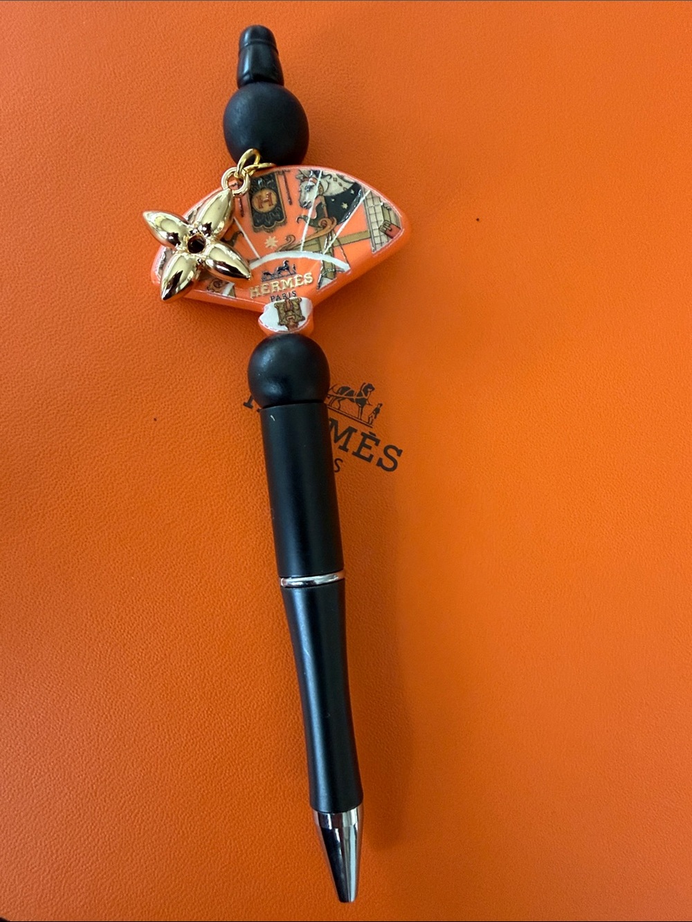 Handcrafted Black and Orange Enamel Charm Pen with Gold Flower Accent